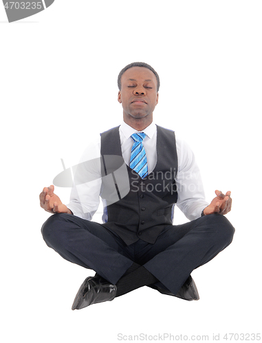 Image of Handsome African man sitting doing yoga