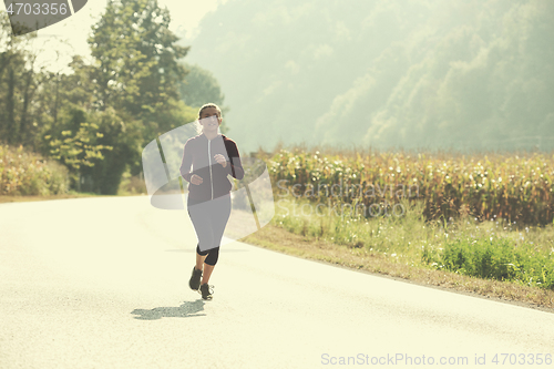 Image of woman jogging along a country road