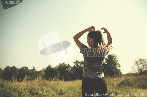 Image of woman jogging along a country road