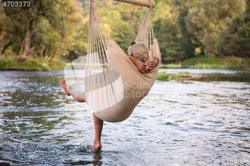 Image of blonde woman resting on hammock