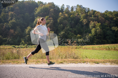 Image of woman jogging along a country road