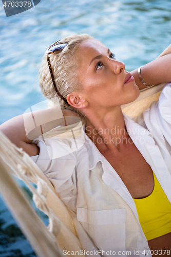 Image of blonde woman resting on hammock