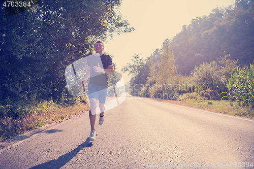 Image of man jogging along a country road