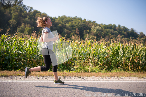 Image of woman jogging along a country road