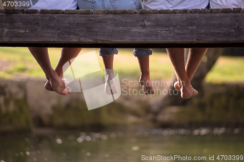 Image of people sitting at wooden bridge