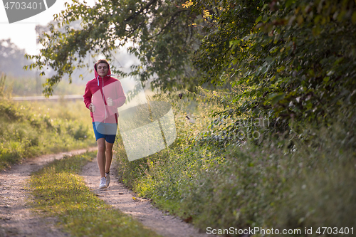 Image of man jogging along a country road