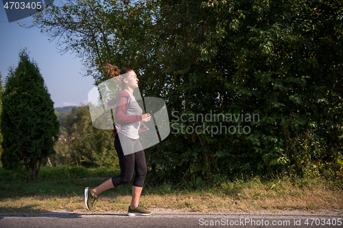 Image of woman jogging along a country road