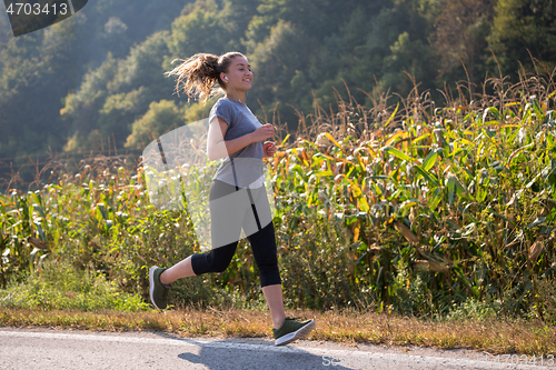 Image of woman jogging along a country road