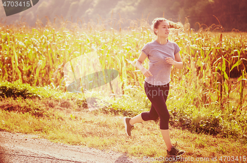 Image of woman jogging along a country road