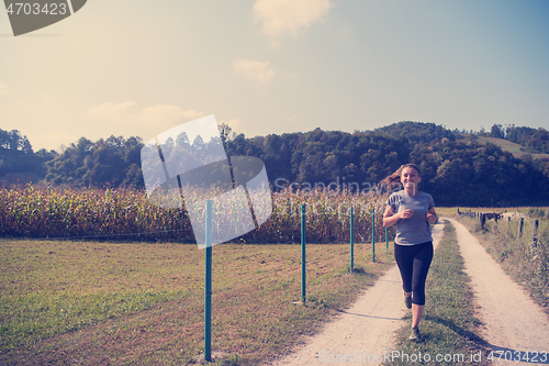 Image of woman jogging along a country road