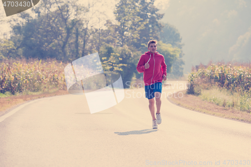 Image of man jogging along a country road