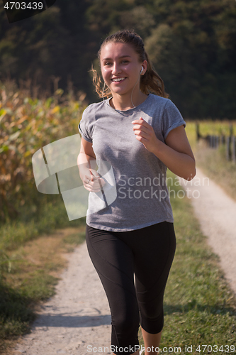 Image of woman jogging along a country road