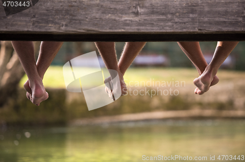 Image of people sitting at wooden bridge