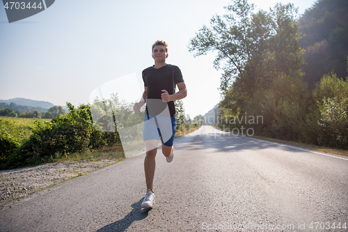 Image of man jogging along a country road