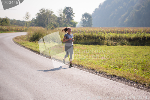 Image of woman jogging along a country road