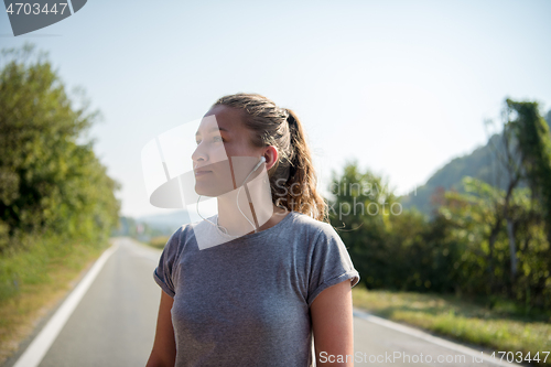 Image of woman jogging along a country road