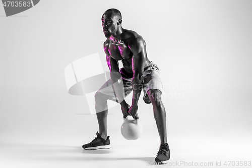 Image of Young african-american bodybuilder training over grey background