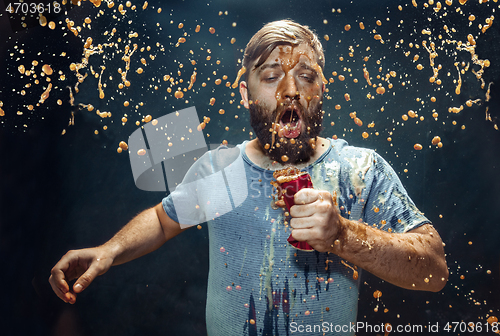 Image of Man drinking a cola and enjoying the spray.