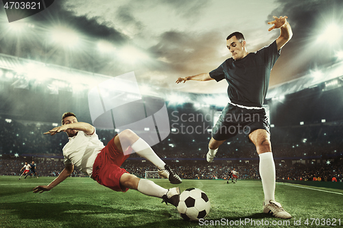 Image of Two men are playing soccer and they compete with each other