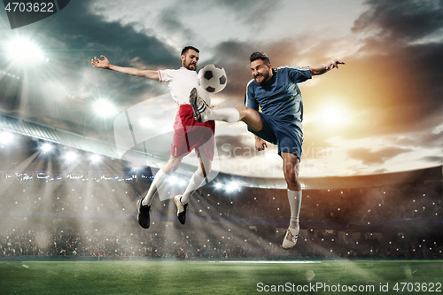 Image of Two men are playing soccer and they compete with each other