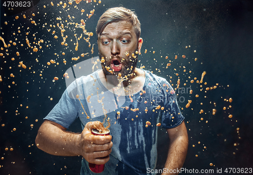 Image of Man drinking a cola and enjoying the spray.