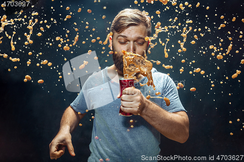 Image of Man drinking a cola and enjoying the spray.