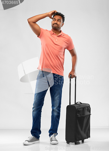 Image of puzzled indian man with travel bag shrugging