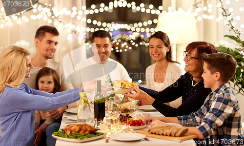 Image of happy family having dinner party at home