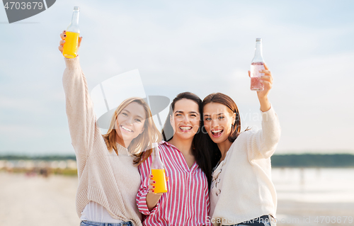 Image of young women toasting non alcoholic drinks on beach