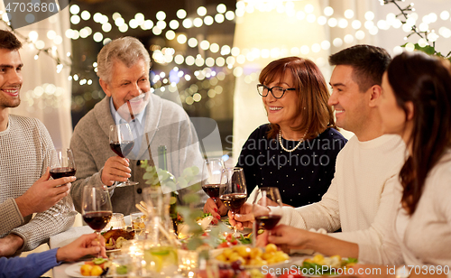 Image of happy family having dinner party at home