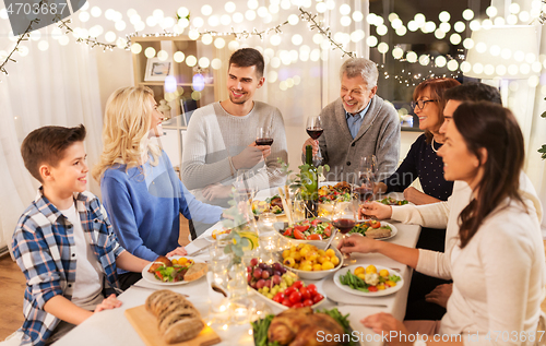 Image of happy family having dinner party at home