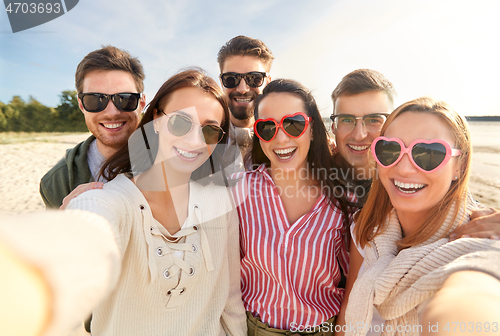 Image of happy friends taking selfie on summer beach