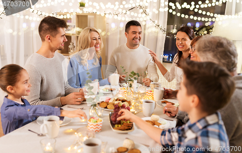 Image of happy family having tea party at home