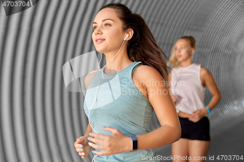 Image of women or female friends with earphones running