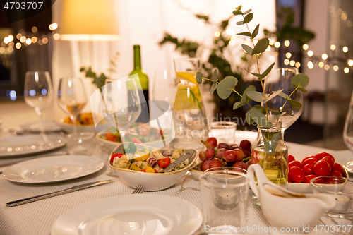 Image of table served with plates, wine glasses and food