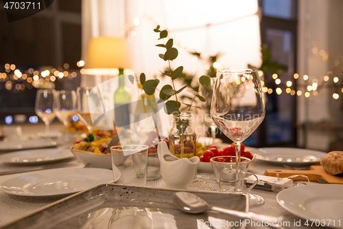 Image of table served with plates, wine glasses and food