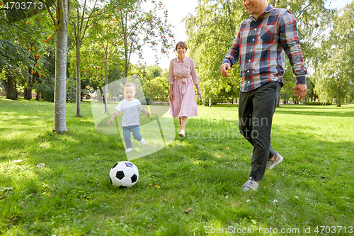 Image of happy family playing soccer at summer park