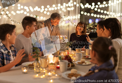 Image of happy family having birthday party at home