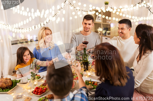 Image of happy family having dinner party at home