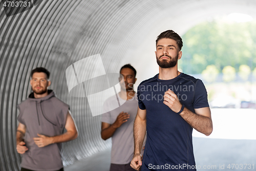 Image of young men or male friends running outdoors