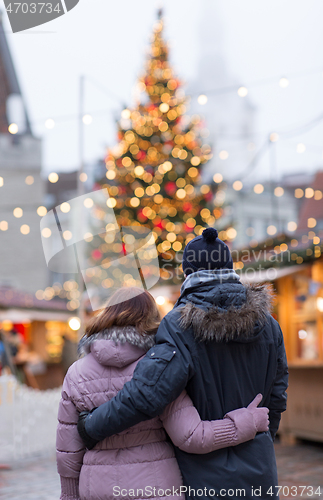 Image of happy senior couple hugging at christmas market