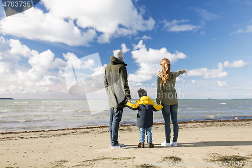 Image of happy family at autumn beach looking at sea