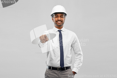 Image of indian male architect in helmet showing something