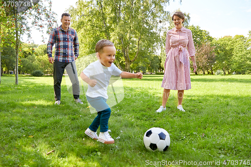 Image of happy family playing soccer at summer park