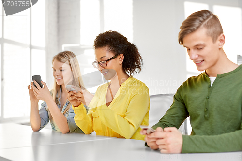 Image of happy high school students with smartphones