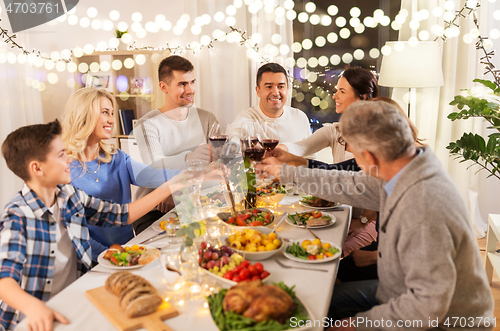 Image of happy family having dinner party at home