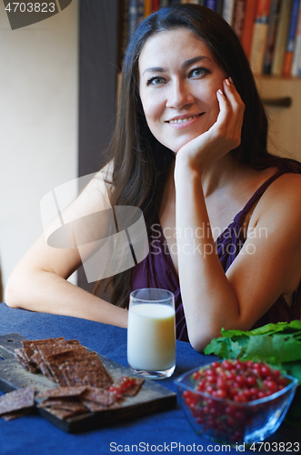 Image of Vegan woman sitting at the table with healthy food