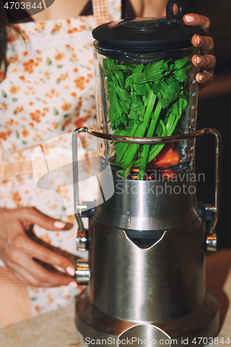 Image of Staying at home woman using electric mixer to prepare vegetarian