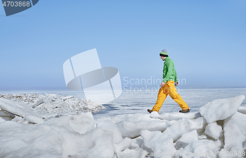 Image of Young adult man outdoors exploring icy landscape