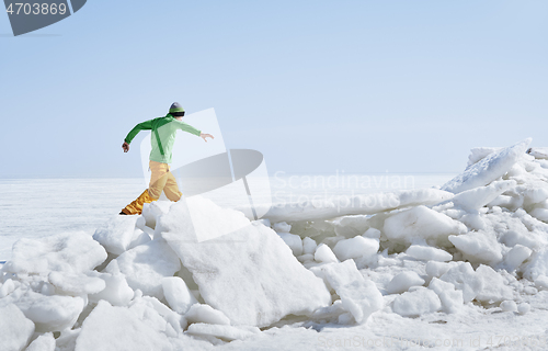 Image of Young adult man outdoors exploring icy landscape